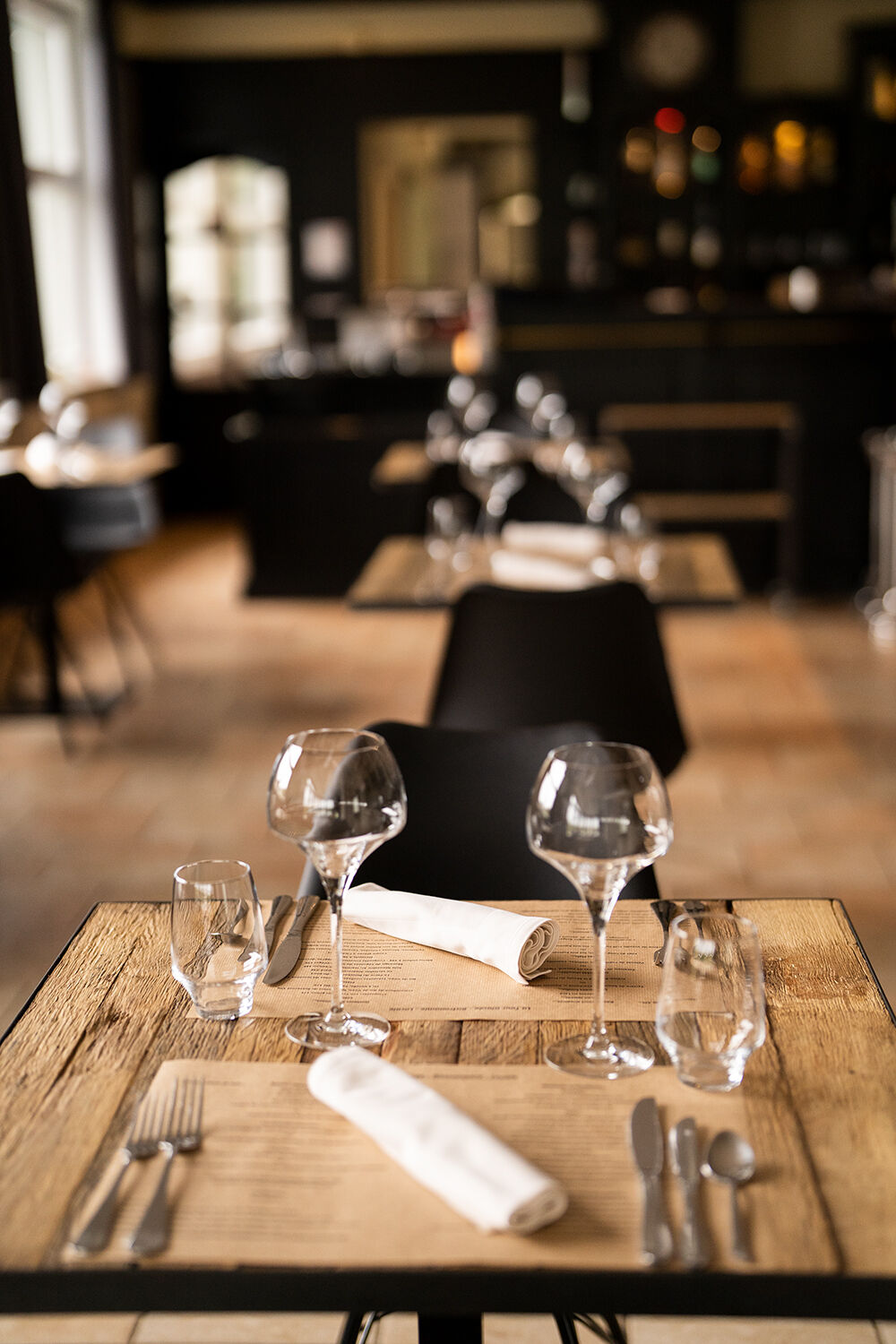 Table de restaurant avec 2 verres et couverts.